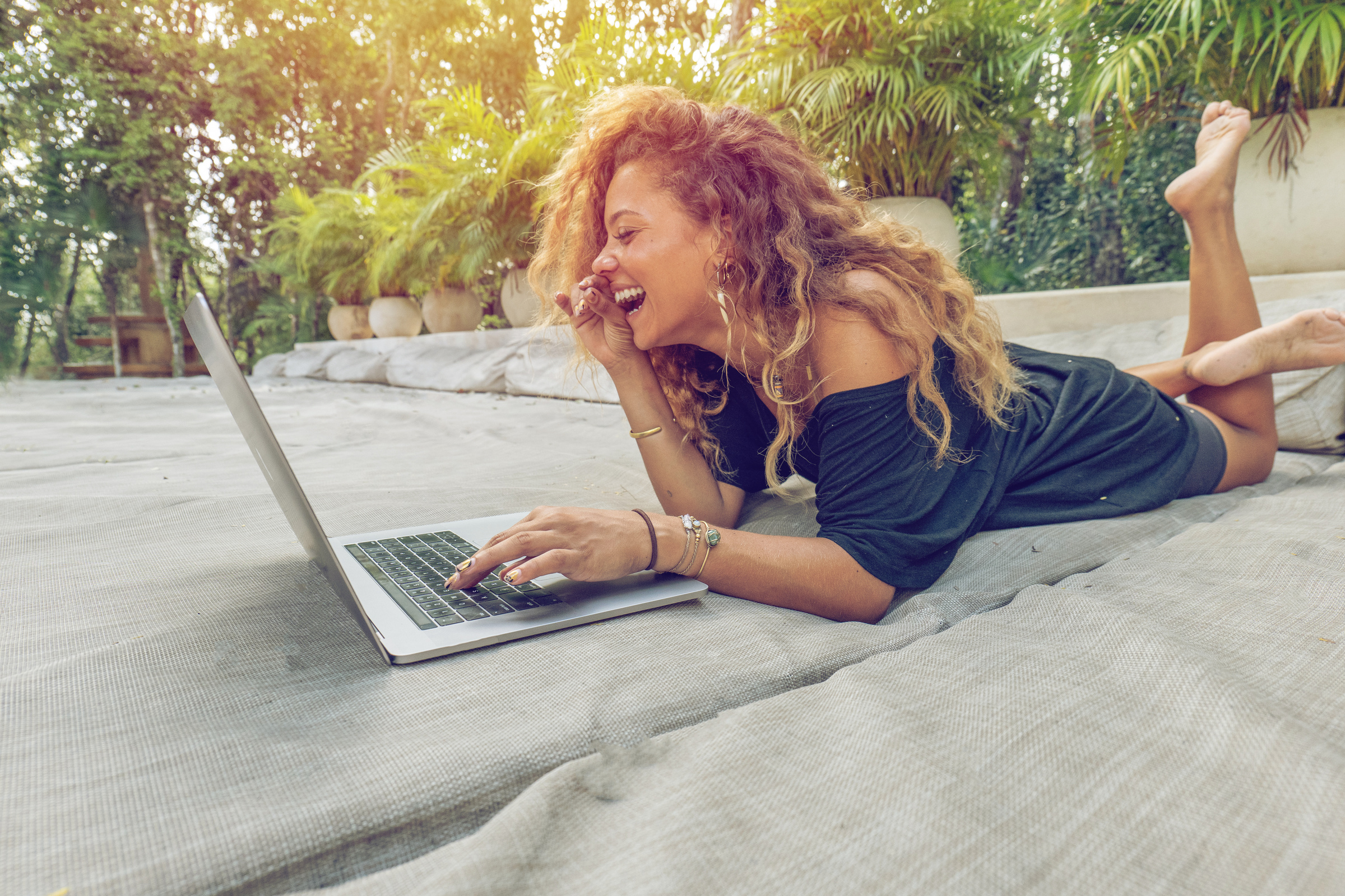 Diverse female working on laptop outdoors, digital nomad lifestyle